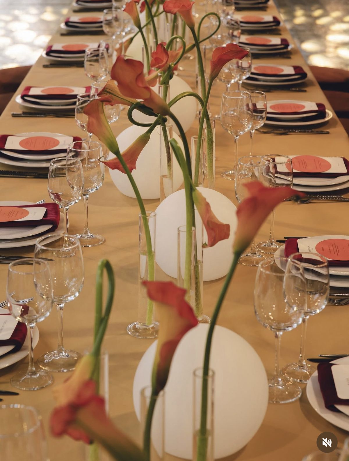 Calla lilies and glowing orbs down a long table