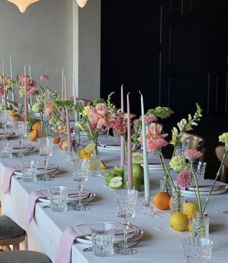 Pastel candles and fruit down a long table